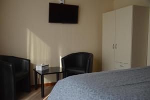 - une chambre avec deux chaises, une table et un lit dans l'établissement B&B The Protea, à Zonnebeke