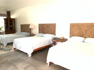 a hotel room with two beds and a table at Villa Bamboo in Coyuca