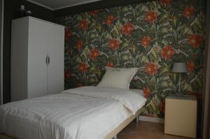 a bedroom with a bed with a floral wallpaper at B&B The Protea in Zonnebeke