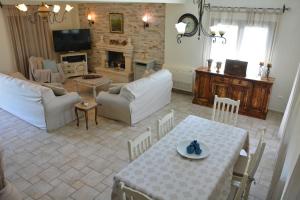 - un salon avec une table, des chaises et un canapé dans l'établissement Villa Alkmini, à Agnítsini