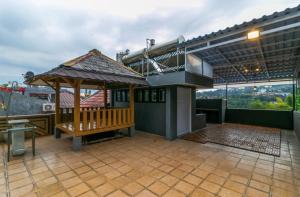 un patio con banco y cenador en Vila Keluarga Syariah Mawar 82, Dago Resort 4BR dengan Privat Pool BBQ dan Rooftop en Bandung