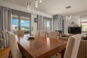 a dining room with a wooden table and chairs at Sea Wind Luxury Villa with Private Heated Pool Kassandra Halkidiki in Nea Fokea