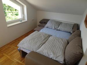 1 dormitorio con cama, sofá y ventana en Turistična kmetija Izgoršek, 