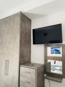 - un salon avec une télévision au-dessus d'une armoire dans l'établissement Zoi Studios, à Kastrópoulon