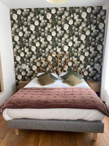 ヴァランジュヴィル・シュル・メールにあるHôtel De La Terrasseの花の壁のベッドルーム1室