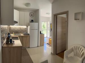 a kitchen with a white refrigerator and a table at Holiday House Sanja Private Terrace BBQ in Peaceful Surroundings in Medulin