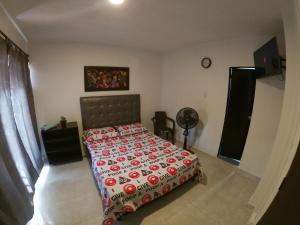 een slaapkamer met een bed met een rode en witte sprei bij Casa Olimpico Hostal in Cali