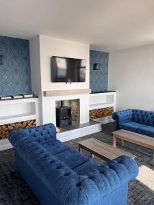 a living room with a blue couch and a tv at Seabank Hotel in Porthcawl