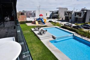 una piscina en un patio con parque infantil en Casa con Vista al Cielo en Aguascalientes