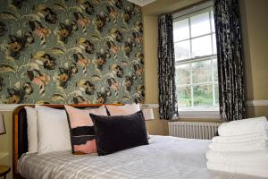 1 dormitorio con 1 cama y papel pintado con motivos florales en Rock House Hotel, en Lynmouth