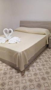 Una cama con dos toallas blancas encima. en Zagara Bianca, en Maiori