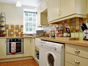 a kitchen with a washer and a dishwasher at Beckside Cottage in Fryup