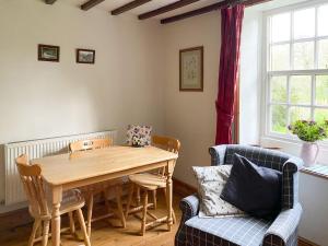 a dining room with a wooden table and chairs at Beckside Cottage in Fryup