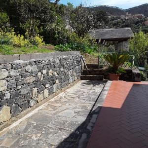 pared de piedra con escalera y camino de piedra en Le Ginestre en Levanto