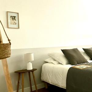 sypialnia z łóżkiem i stołem z lampą w obiekcie La Petite Maison du 9 w mieście Saint-Aignan