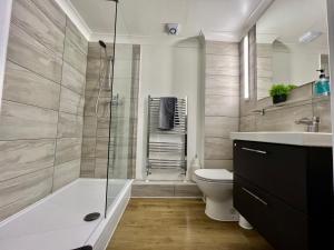 a bathroom with a shower and a toilet and a sink at Pomelo Tree Apartment in Cambridge