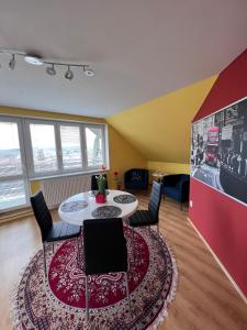 a living room with a table and chairs and a red rug at Ubytování v soukromí na Vysočině 