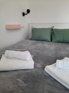 a bedroom with two white towels on a bed at Studio apartmani Venium in Križevci