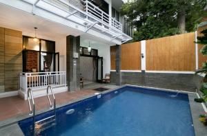 a swimming pool in front of a building at Vila Keluarga Syariah Mawar 82, Dago Resort 4BR dengan Privat Pool BBQ dan Rooftop in Bandung