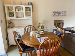 a dining room with a wooden table and chairs at Primrose Cottage in Winewall