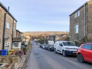 a row of cars parked on the side of a street at Primrose Cottage in Winewall