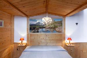 um quarto com uma cama e um quadro na parede em Affittacamere Lozen em Canale San Bovo