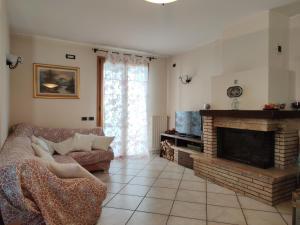 ein Wohnzimmer mit einem Sofa und einem Kamin in der Unterkunft Relax in collina a due passi dal mare in Torriana
