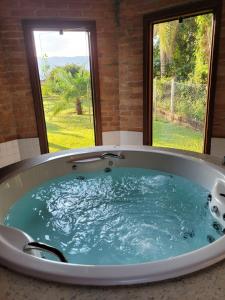若阿諾波利斯的住宿－Contempla Joanópolis，窗户前的浴缸里装满了蓝色的水