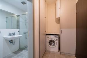 y baño con lavadora y lavamanos. en Casa Dolce Far Niente, 2BATH&2BED en Sofía