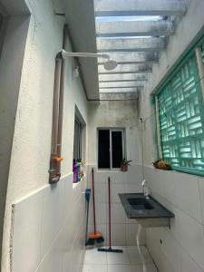 uma casa de banho com um lavatório e uma janela em apartamento mobiliado perto das praias em Natal