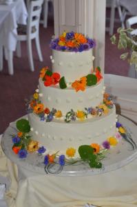a white wedding cake with flowers on a table at The Brandon Inn in Brandon