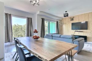 uma sala de estar com uma mesa de madeira e cadeiras em GOOD VIBES ONLY -Modern and spacious 2 bedroom condo 4 beds FREE PARKING, GYM em Quebeque