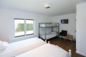 ein weißes Schlafzimmer mit einem Etagenbett und einem Schreibtisch in der Unterkunft Casa Dunas in Middelkerke