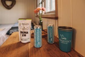 three cans of popcorn sitting on a wooden table at Luxury Shepherd's Hut on Flower Farm with Outdoor Bath in Mid Cornwall in Truro