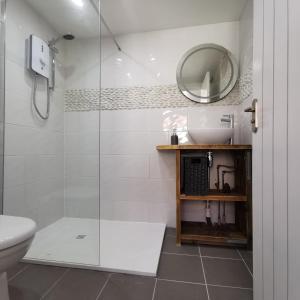 a bathroom with a shower and a sink and a mirror at AnchorageWells Lodge, Seaview Apartment in Wells next the Sea
