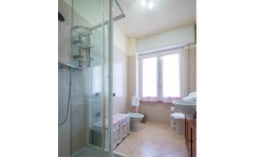 een badkamer met een douche, een toilet en een wastafel bij Lake view apartment with parking in Dongo - Larihome A26 in Dongo