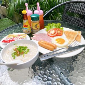 a table with a plate of food and a bowl of soup at The Harmony Ville in Phitsanulok