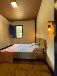 ein Schlafzimmer mit einem großen Bett in einem Zimmer in der Unterkunft Fazenda do Quartel in Manhumirim