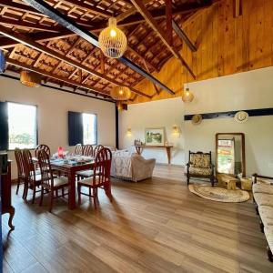 a living room with a table and chairs and a bedroom at Fazenda do Quartel in Manhumirim