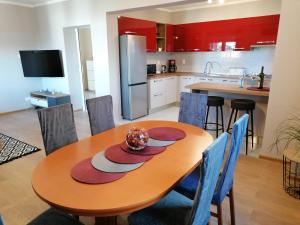 a kitchen with a wooden table with blue chairs at Apartman Nina in Kali
