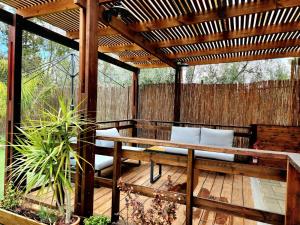 a patio with a wooden pergola and a bench at Extreme Sports Arad in Arad