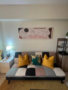 a living room with a couch with colorful pillows at JmR Serin West studio unit pay by Gcash or cash only in Tagaytay