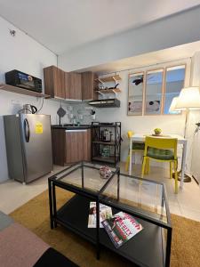 ein Wohnzimmer mit einem Tisch und einer Küche in der Unterkunft JmR Serin West studio unit pay by Gcash or cash only in Tagaytay