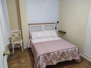 niewielka sypialnia z łóżkiem i krzesłem w obiekcie Casa Cubillas w mieście Teruel