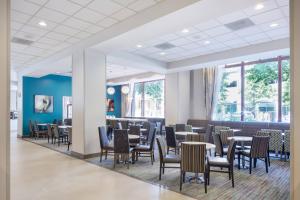 a dining room with tables and chairs and windows at Residence Inn Portland Downtown/RiverPlace in Portland