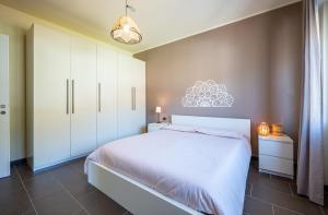 een slaapkamer met een wit bed en witte kasten bij Lake view apartment with parking in Dongo - Larihome A26 in Dongo