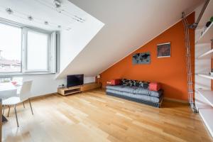 米兰tHE Orange Attic - Navigli Area的橙色的客厅配有沙发和电视