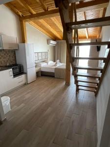a room with a staircase and a kitchen and a bedroom at Hotel Horizontas in Nea Plagia