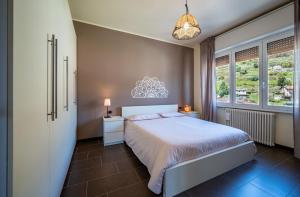 een slaapkamer met een bed en een groot raam bij Lake view apartment with parking in Dongo - Larihome A26 in Dongo