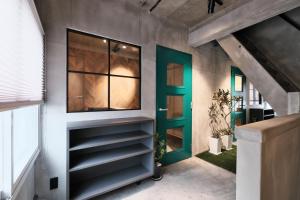 a hallway with a green door and shelves at SHIN kyoto in Kyoto